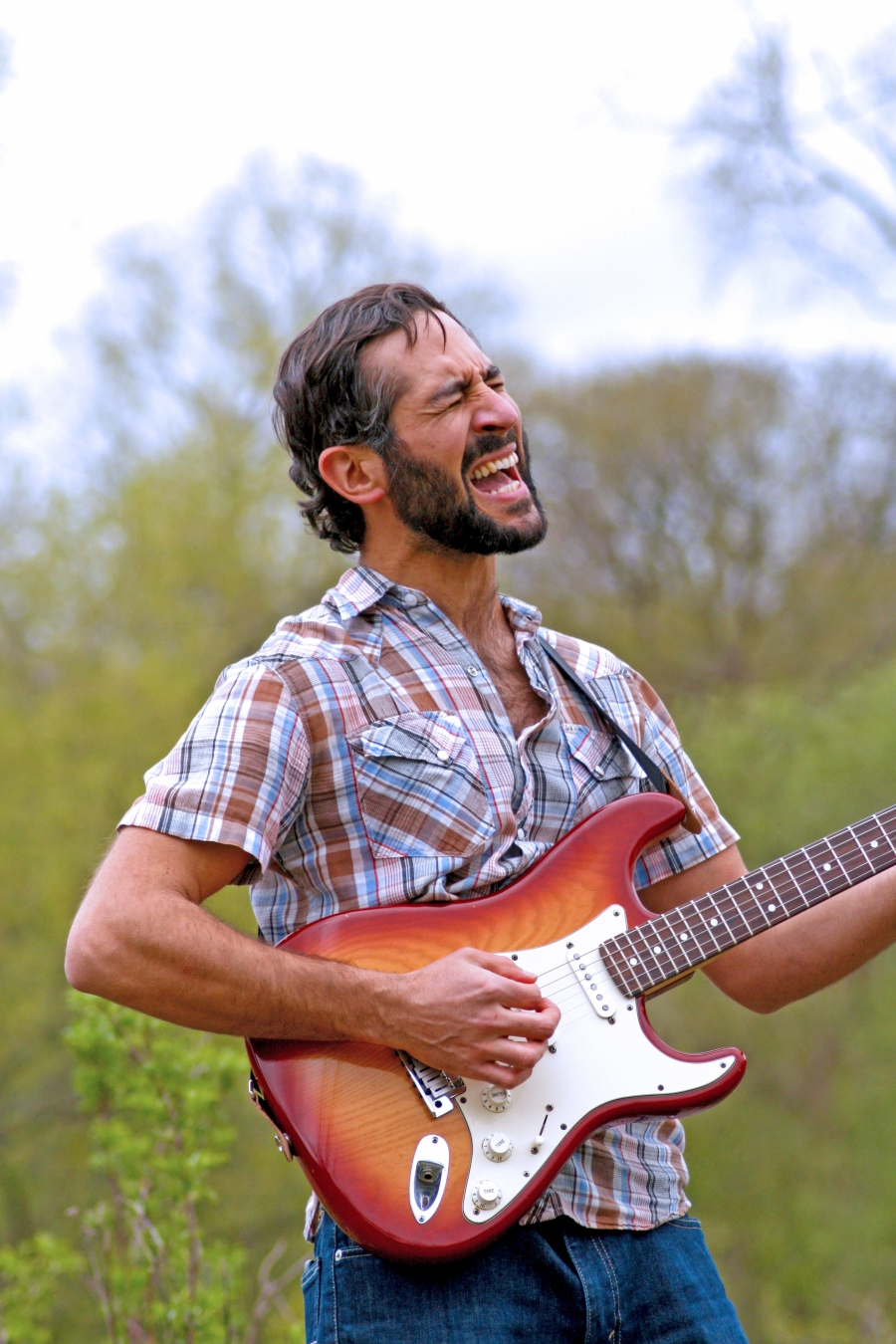 Nima Samimi, a.k.a Muhammad Seven. Man in field with electric guitar